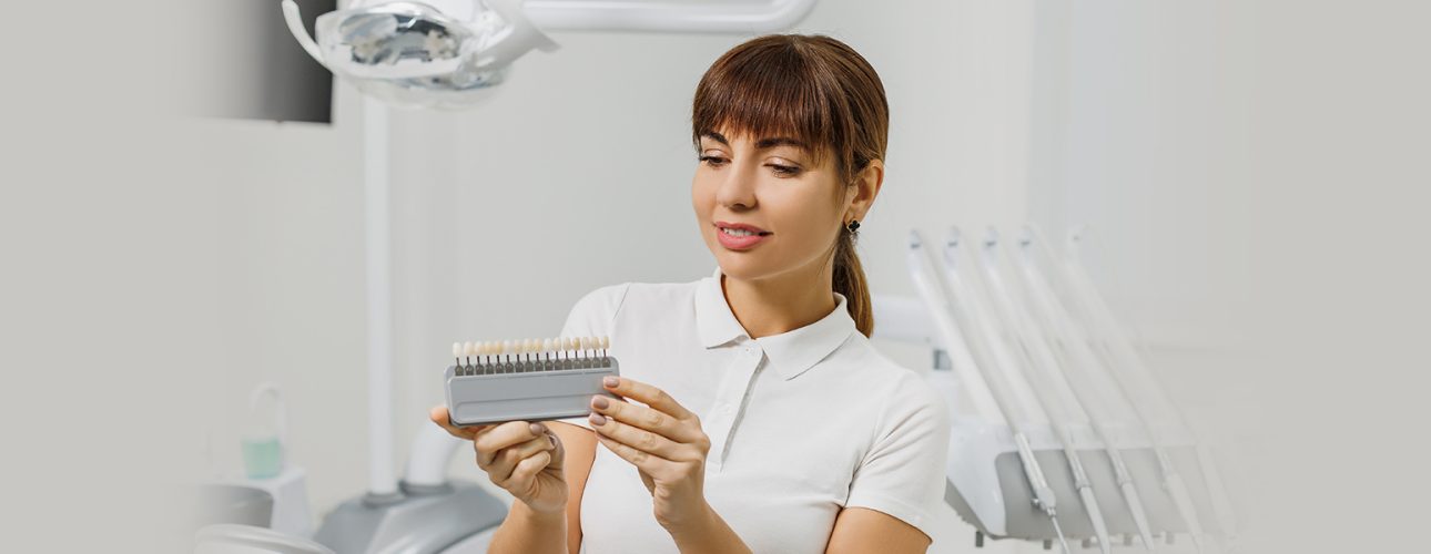 A lady holding dental veneers in hand