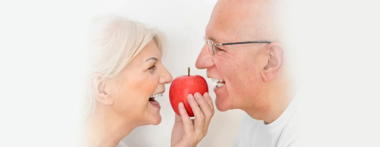 An old couple smiling after getting dentures