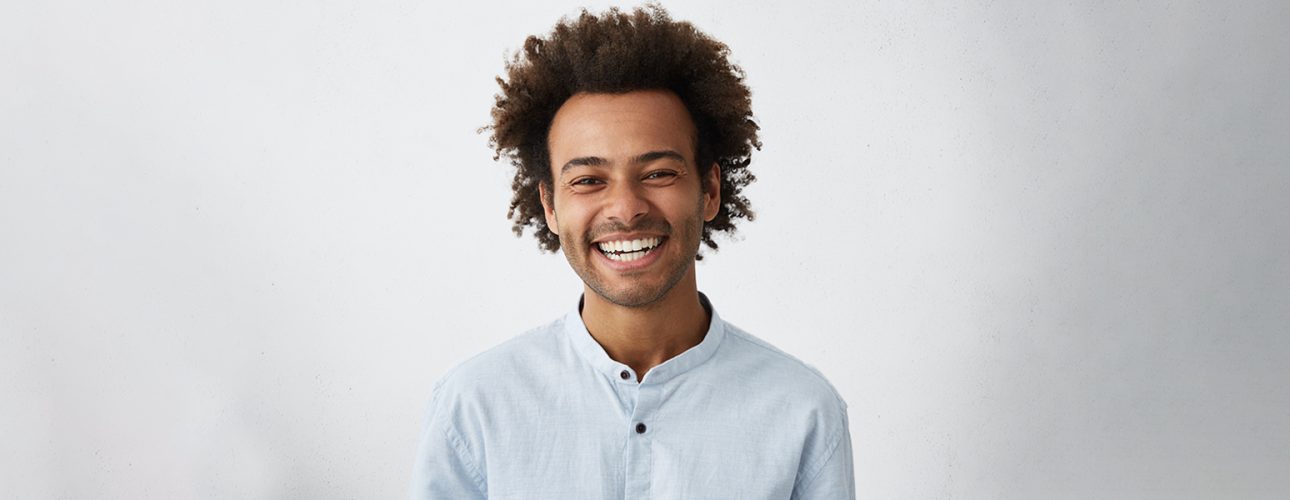 A man smiling after getting teeth whitening treatment