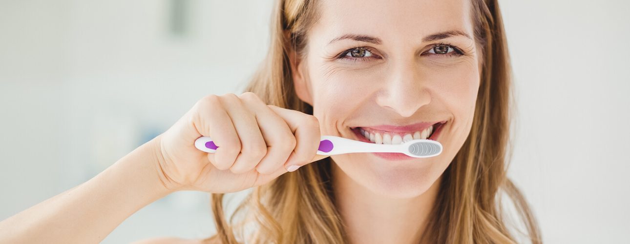A lady brushing her teeth